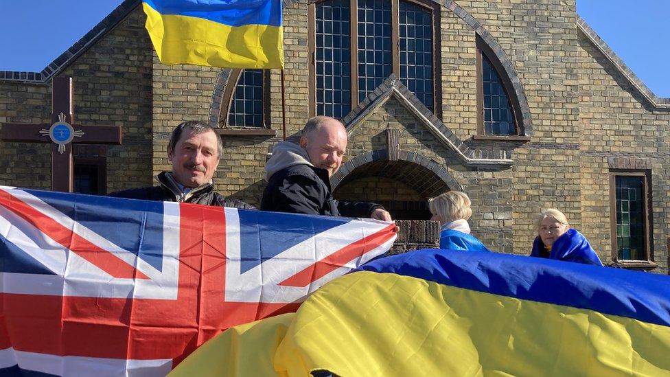 People holding Ukraine and the Union flag outside St Olga's Ukrainian Church in Peterborough on 27 February