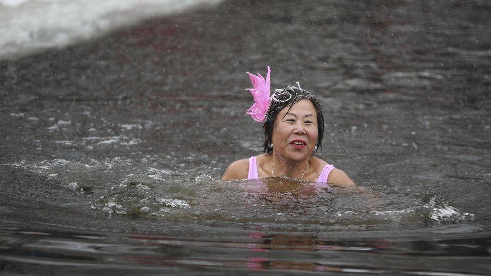 Woman smiling as she swims through freezing water