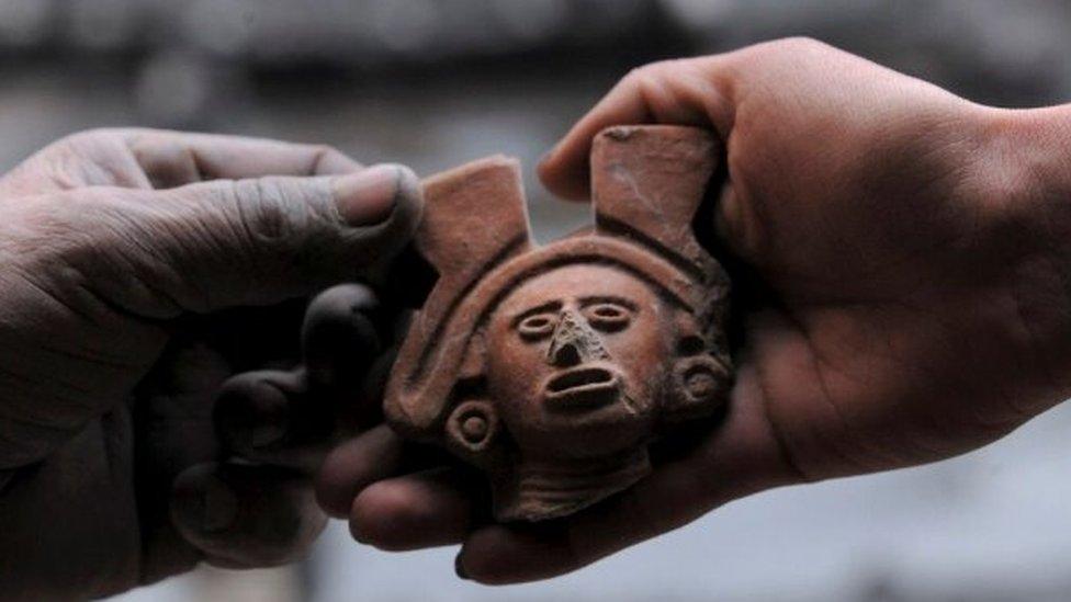 An anthropomorphic figure is held by an archaeologist, part of an altar unearthed by archaeologists at a plot near Plaza Garibaldi in downtown Mexico City