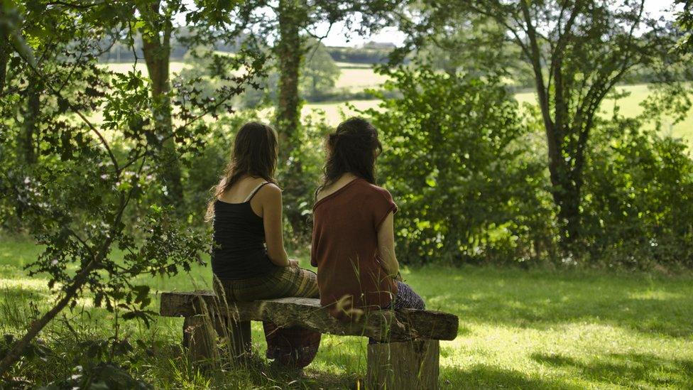 Two women sat on a bench outside during a silent retreat