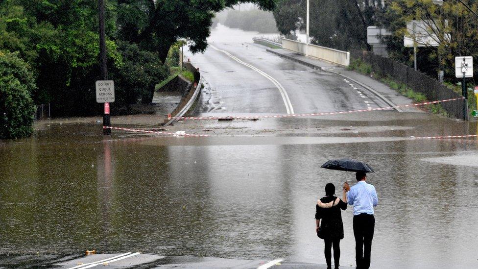 People look out at a flooded residential area in the Windsor area in northwestern Sydney on March 23, 2021