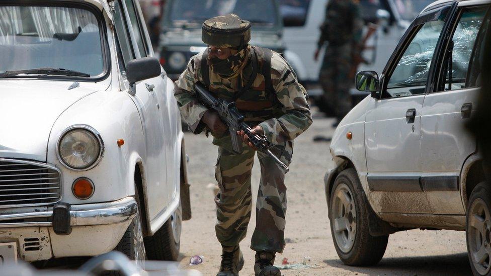 An Indian army soldier takes position during a fight in the town of Dinanagar, in the northern state of Punjab, India, Monday, July 27, 2015.