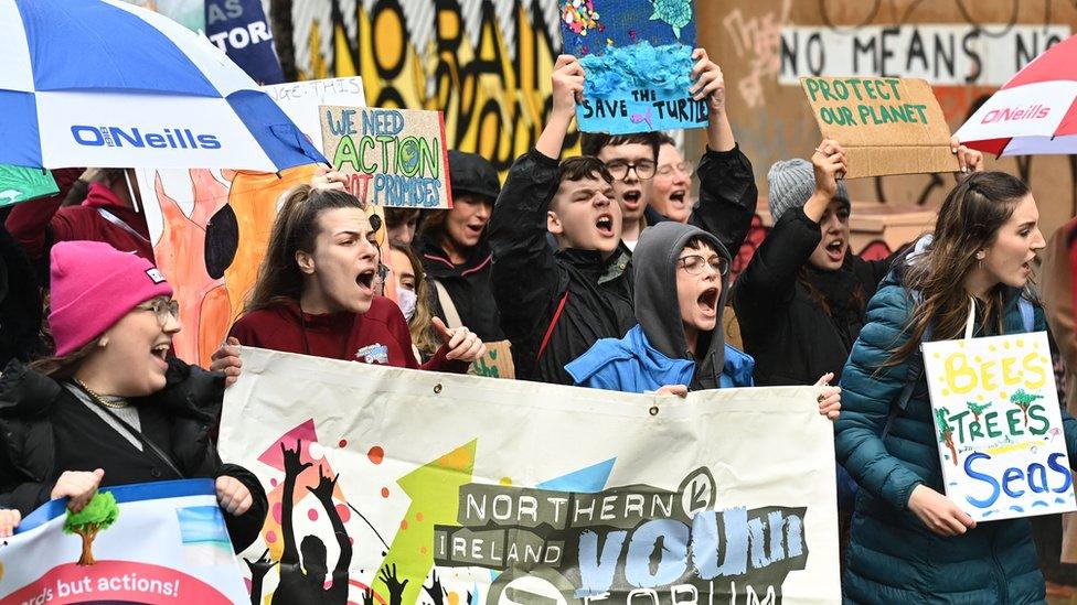 Protesters chant and hold placards at the climate change rally in Belfast