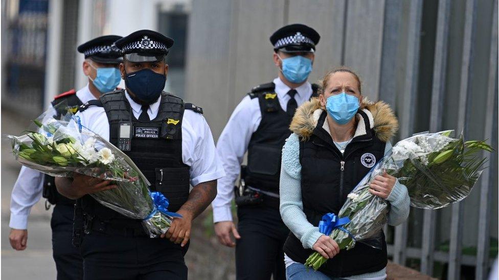 police and public leave flowers at station