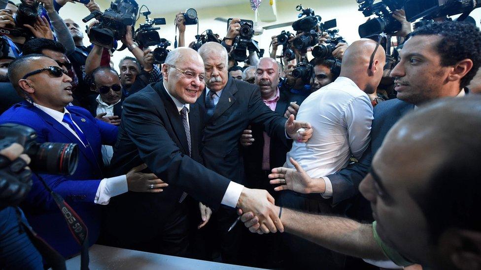 Moussa Mustafa Moussa (C) shakes hands with supporters at a polling station in Cairo on 26 March 2018