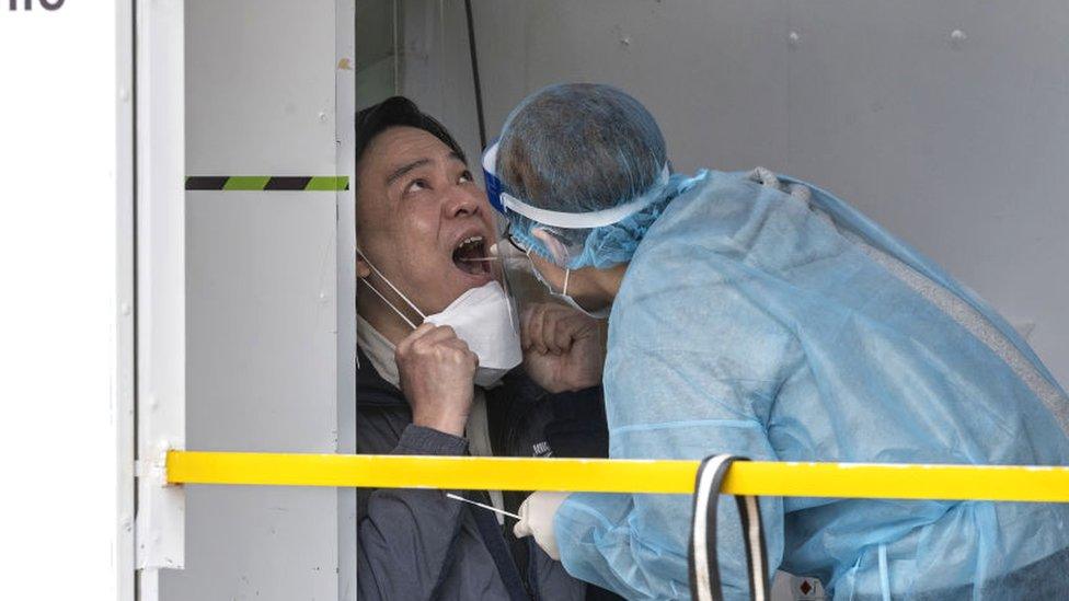 A resident receives a PCR test for coronavirus (Covid-19) at Central financial district testing center in Hong Kong on February 9, 2022