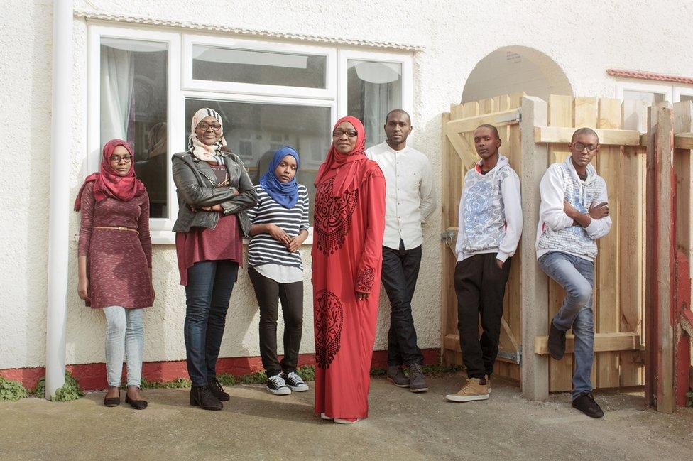 A family stand outside their house