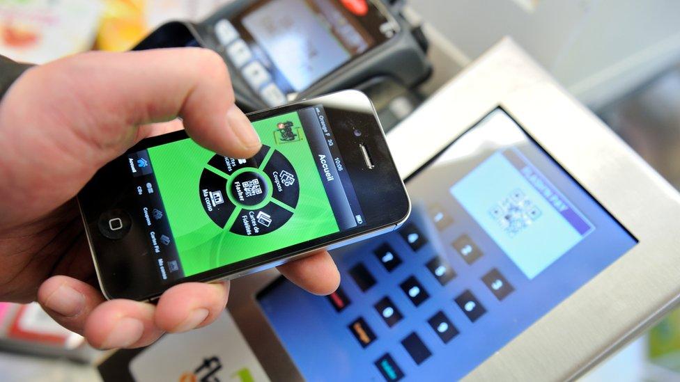 Someone paying for groceries using mobile phone