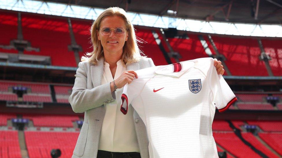 Sarina Wiegman holding an England shirt