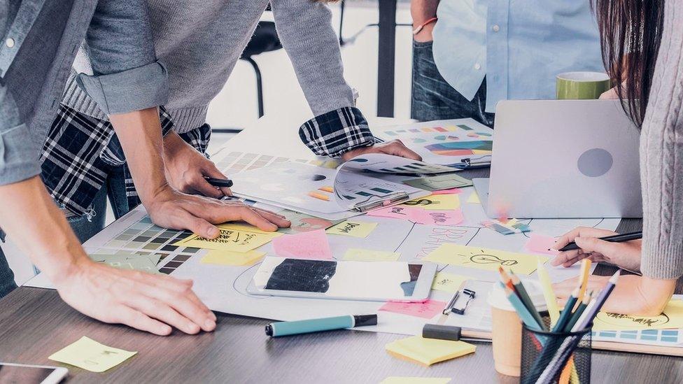 People standing around a desk