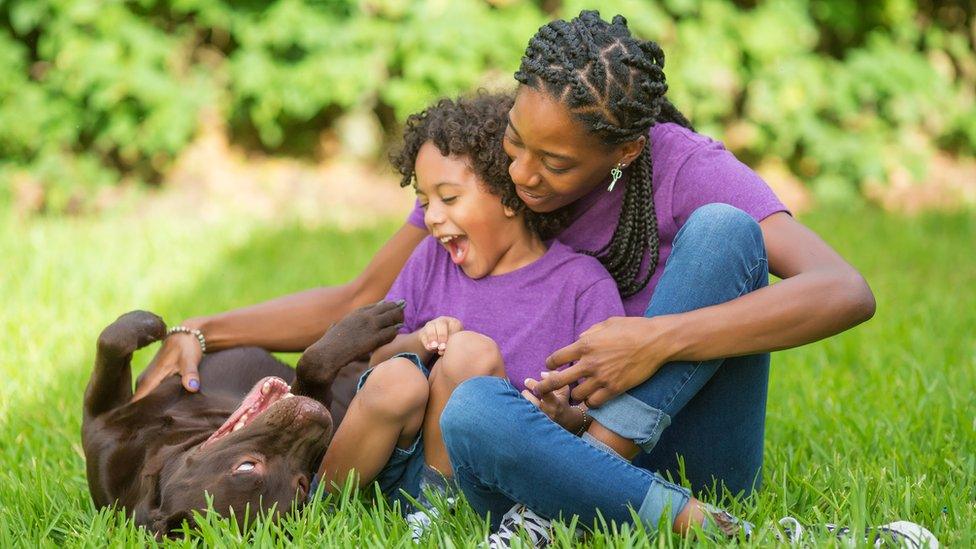 Girl and her mum with labrador.