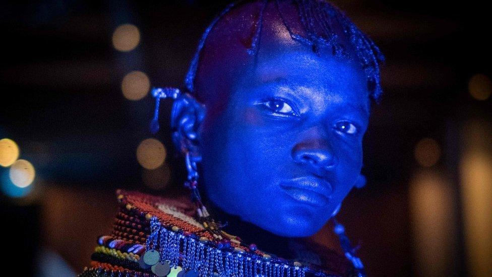 A dancer of Turkana tribe performs in blue light during the launching ceremony of the 11th Marsabit-Lake Turkana Cultural Festival in Nairobi, Kenya, on June 20, 2018.