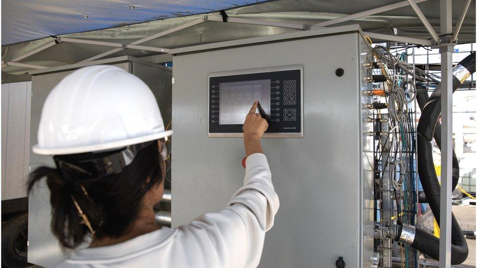 An engineer works on a hybrid direct air carbon capture technology pilot site in Bakersfield, California, U