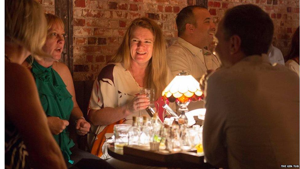 Men and women sit around the table at the Gin Tub without any mobile signal