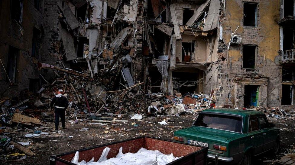 A man picks up personal belongings from the apartment he used to live in in Kramatorsk, Donetsk