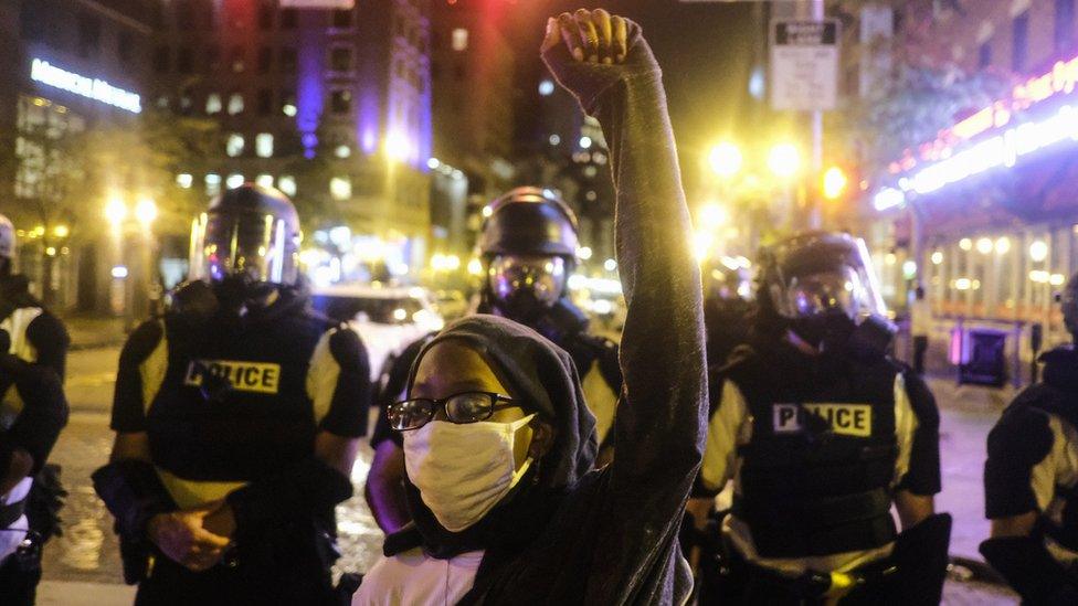 A protester raises her hand outside the Ohio statehouse in Columbus (28 May 2020)