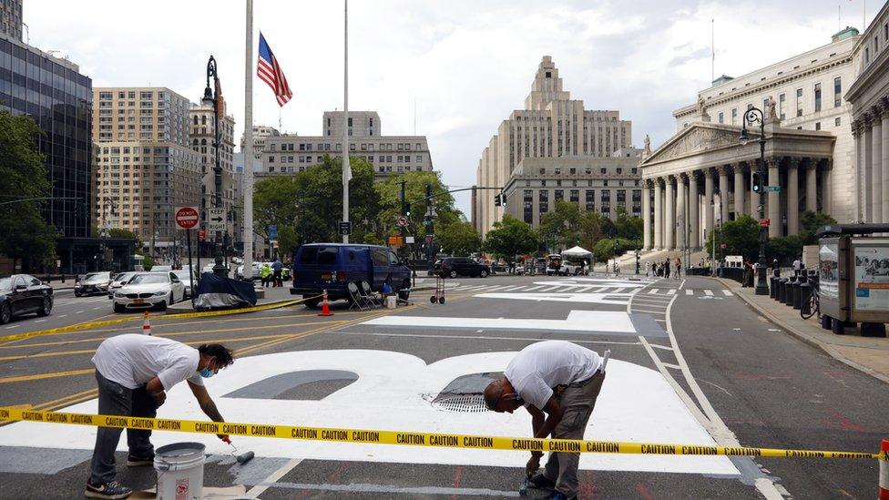 Two men work on the recently painted giant letters spelling out "Black Lives Matter" as seen in front of the Federal Court in Lower Manhattan in New York, USA, 01 July 2020