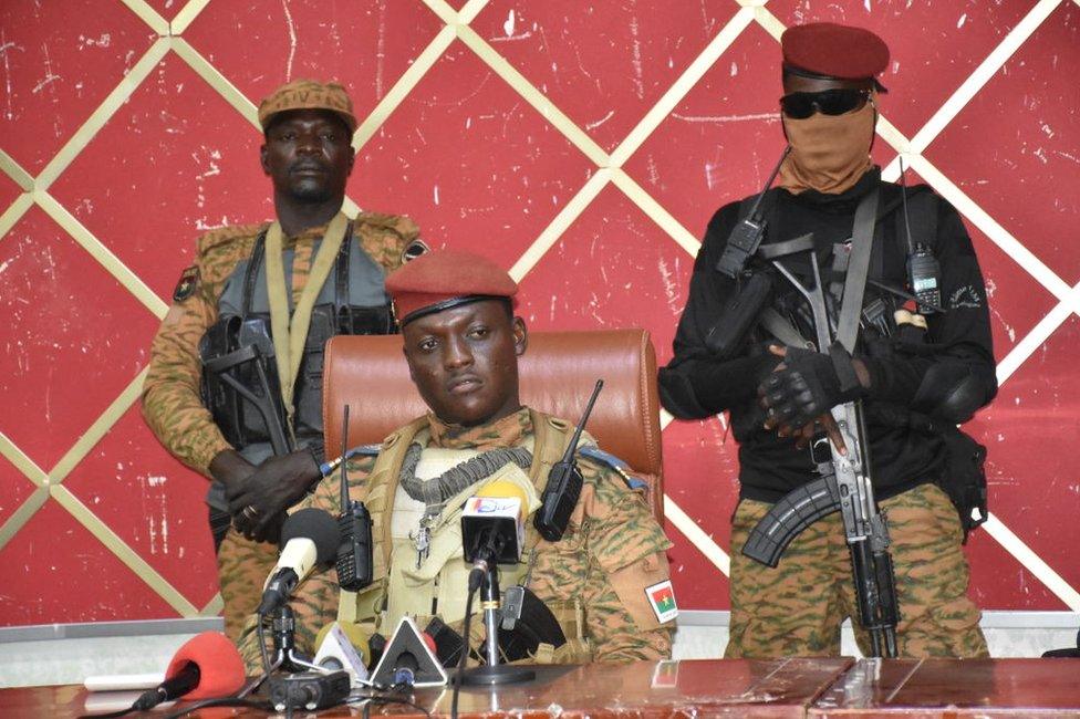 Capt Ibrahim Traoré flanked by soldiers as he addresses politicians.