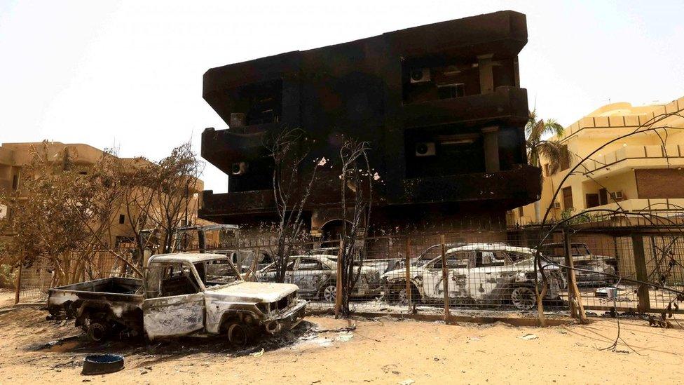 A charred building and cars in Khartoum, Sudan. Photo: April 2023