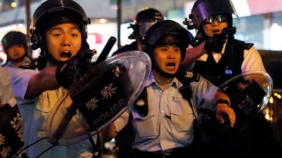 Police officers point their guns towards anti-extradition bill protesters