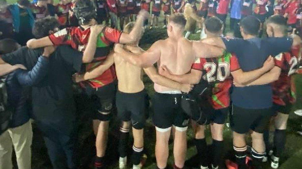 Boys hugging after playing rugby