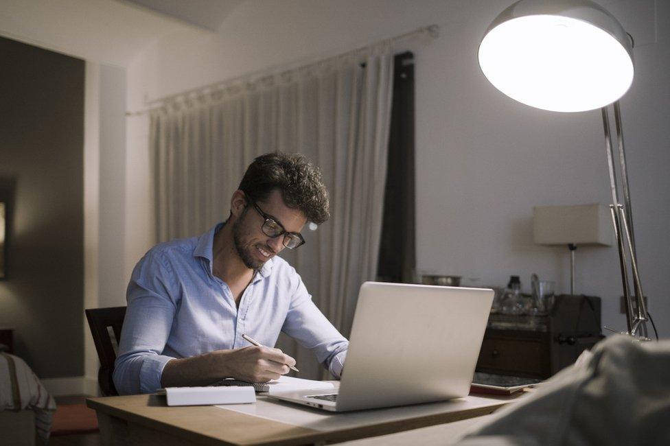 Man working at home with the lights on