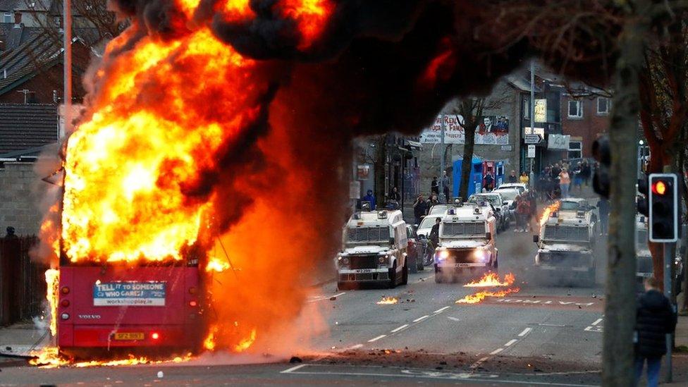 A bus burns on a street in west Belfast