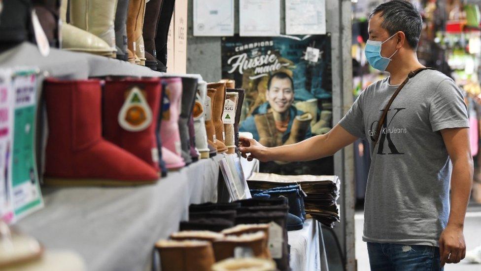 Trader arranges products in store in Melbourne on 29 October 2020