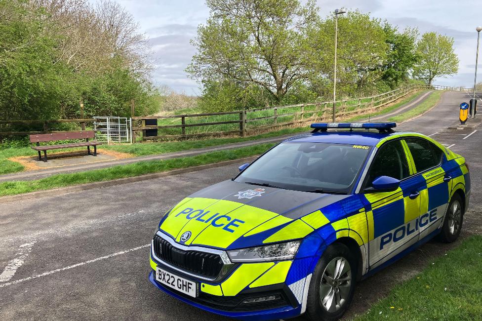 Police car at the scene where a dog walker was attacked in Astill Lodge Road, Leicester