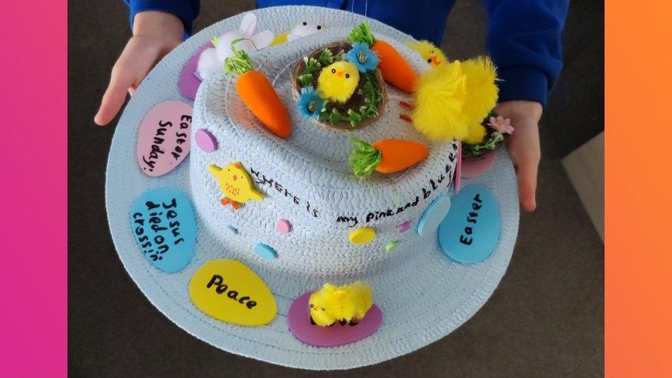 Blue straw Easter bonnet with chicks and decorations.