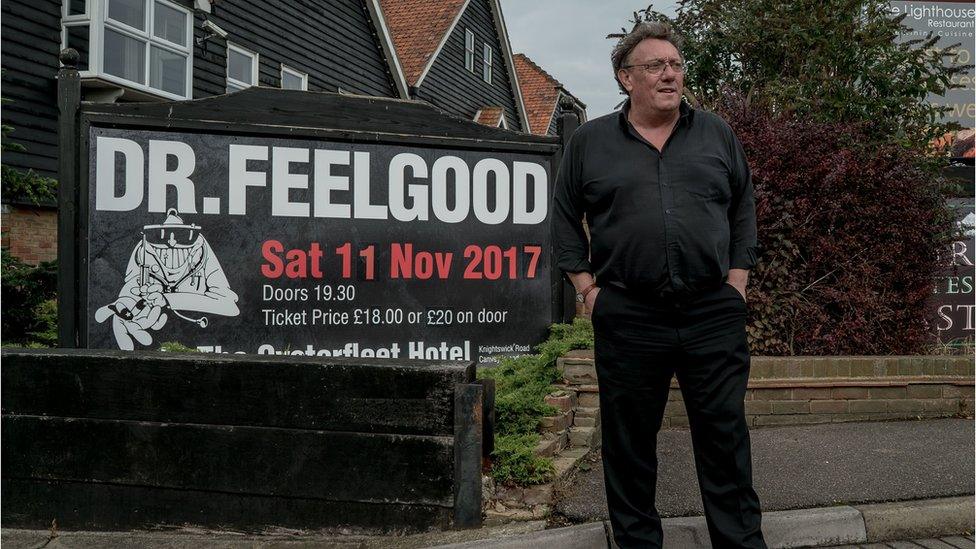 Chris Fenwick beside a Dr Feelgood poster