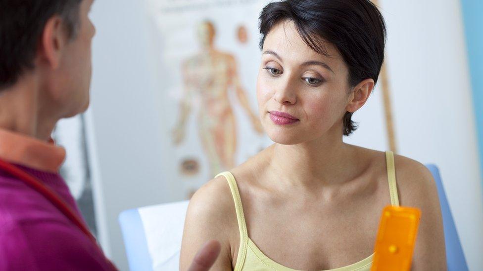 A woman as a doctor gives her a pill