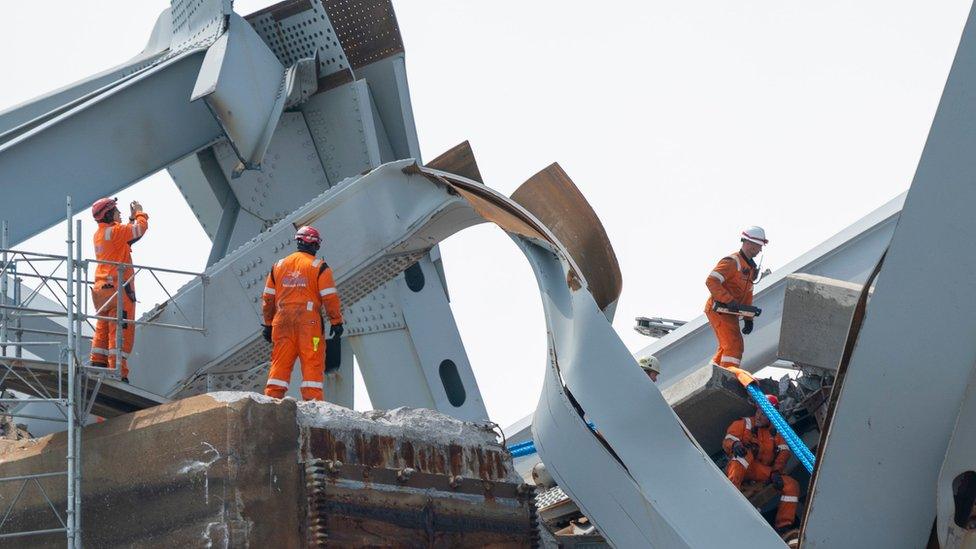 Crews work to remove the wreckage of the Francis Scott Key Bridge atop the cargo vessel Dali in the Patapsco River