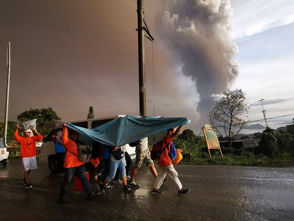 An ash column from erupting Taal Volcano looms over Tagaytay city, Philippines, 12 January