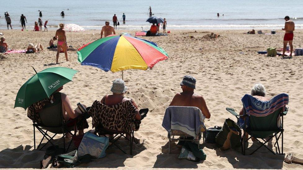 People sitting on a beach in hot weather
