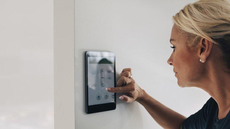 Generic image of woman turning down thermostat