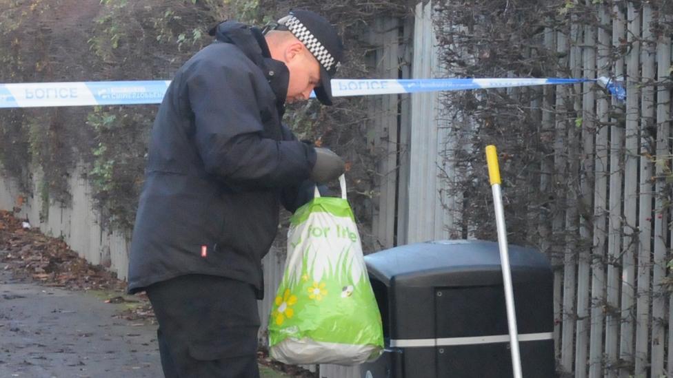 Police officer checking bins