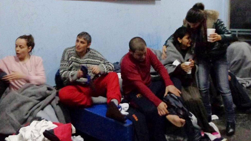 Survivors of Friday's boat sinking off Kalolimnos change clothes on Kalymnos, 22 Jan