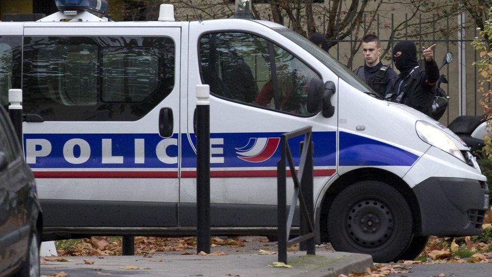 Police officers gesture during a search in the house of the mother of the female suicide bomber Hasna Ait Boulahcen, in Aulnay-sous-Bois, near Paris