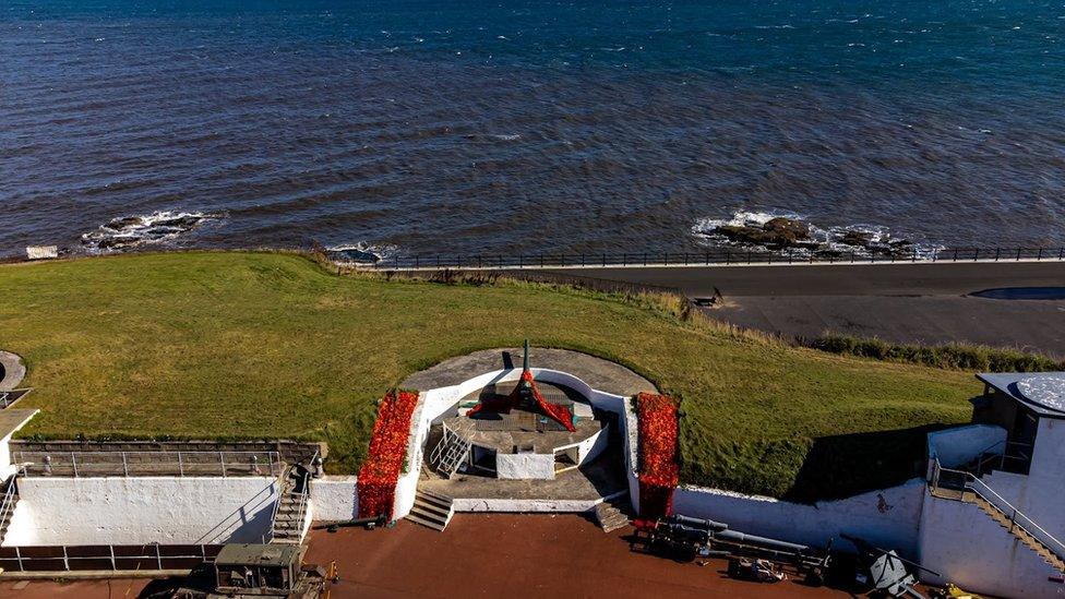 A large gun mounted at a battery overlooking the sea