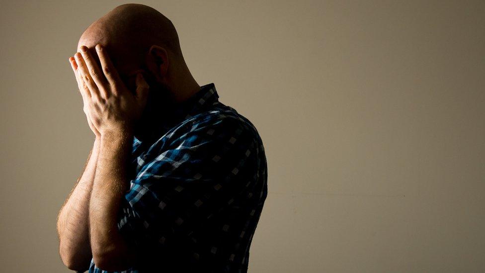 Man holding his head in his hands (posed by model)