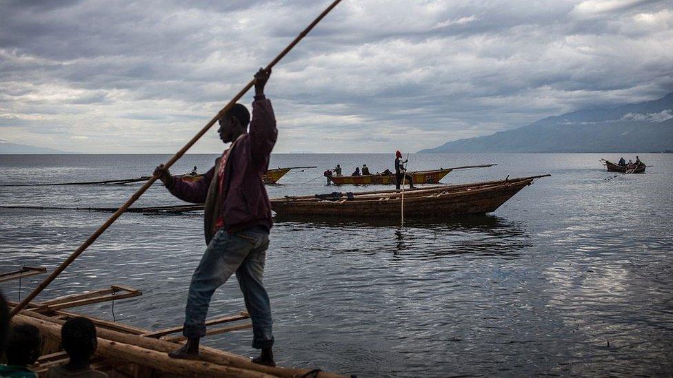 Fisherman manoeuvre to dock their boats on Tanganyika lake in Uvira on March 22, 2015