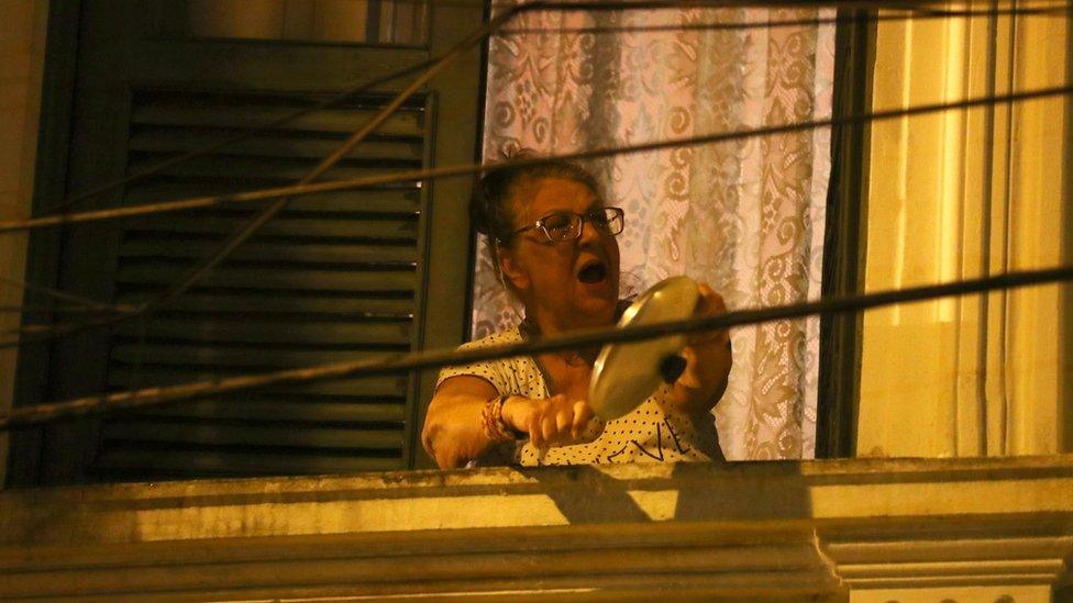 A woman in Rio de Janeiro beats a pot and pan during Jair Bolsonaro's speech