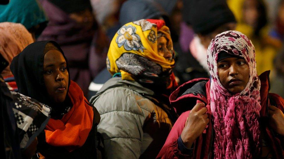 Migrants wait before entering buses