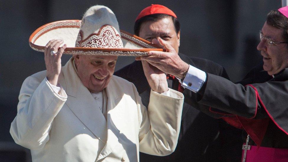 Pope Francis dons a Mexican charro style sombrero that was given to him by a person in the crowd, in Mexico City