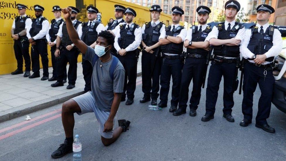 Police stand behind a protester