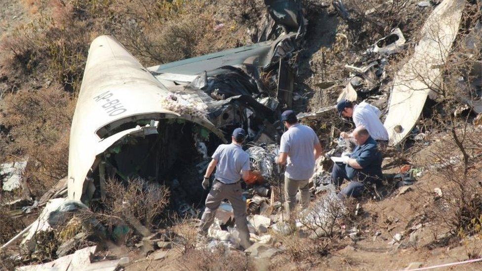 Overseas investigators examine the wreckage of a Pakistan International Airlines (PIA) passenger plane which crashed near the village of Saddha Batolni in the Abbottabad district of Khyber Pakhtunkhwa province on December 13, 2016