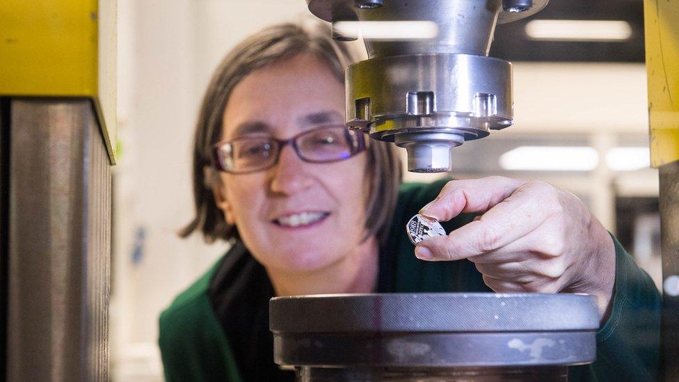 Helen Pankhurst striking the new 50p coin marking 100 years of the Representation of the People Act