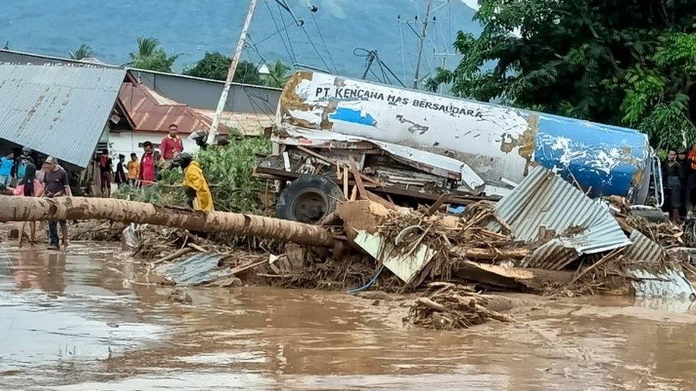 Fallen trees and debris are seen in the aftermath of flooding in Indonesia