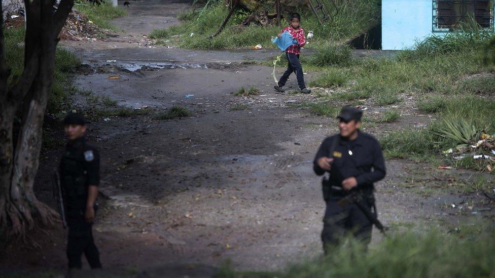 Two policement patrolling a poor neighbourhood